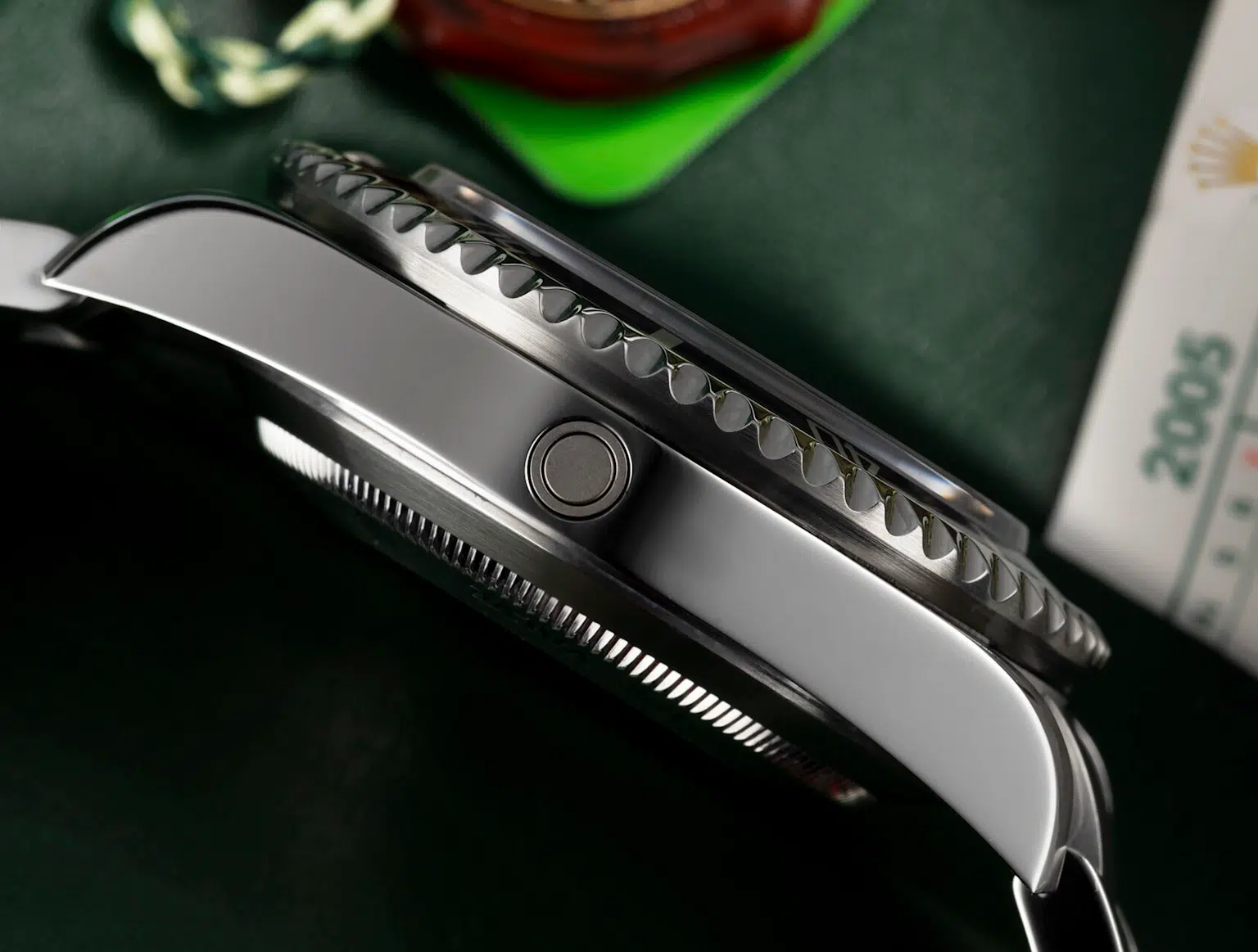 Close-up of an aluminum watch bezel with serrated edges on a Rolex Sea-Dweller dive watch