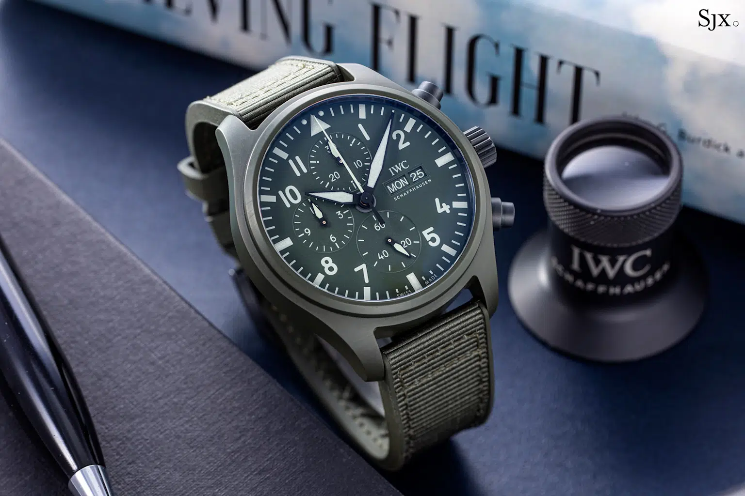 Close-up of the IWC Pilot's Chronograph watch showcasing its green dial, bold Arabic numerals, oversized crown, and day-date complication